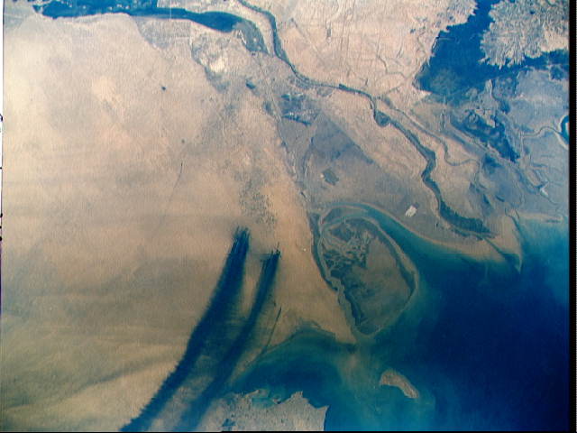 space shuttle view of Kuwaiti desert showing pl.umes of smoke from massive oil spills and oil fires