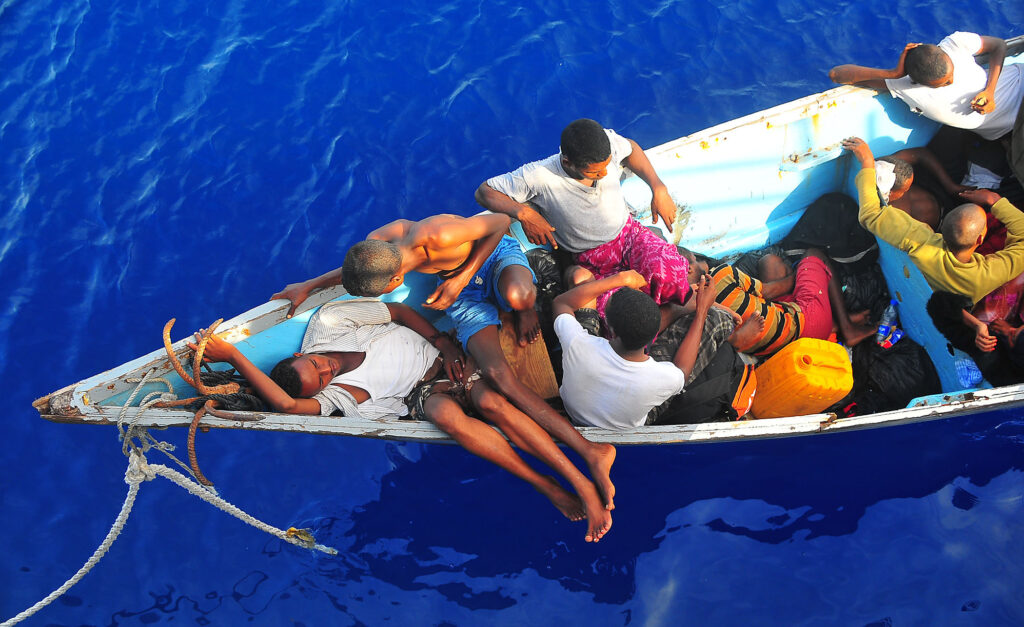 Somali migrants in a disabled skiff wait for assistance from U.S. Navy sailors.